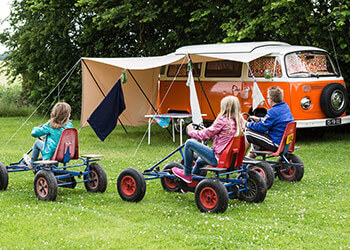 Kinder mit Gokarts auf Campingplatz